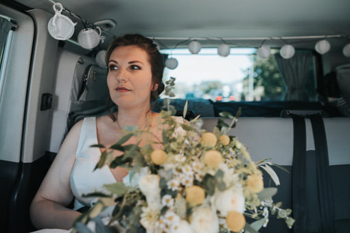 Braut im Hochzeitsauto auf dem Weg zur Trauung