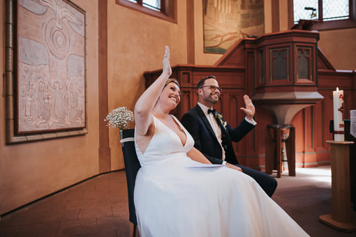 Hochzeit-im-Heyligenstaedt Brautpaar in der Kirche winkt den Gästen zu.