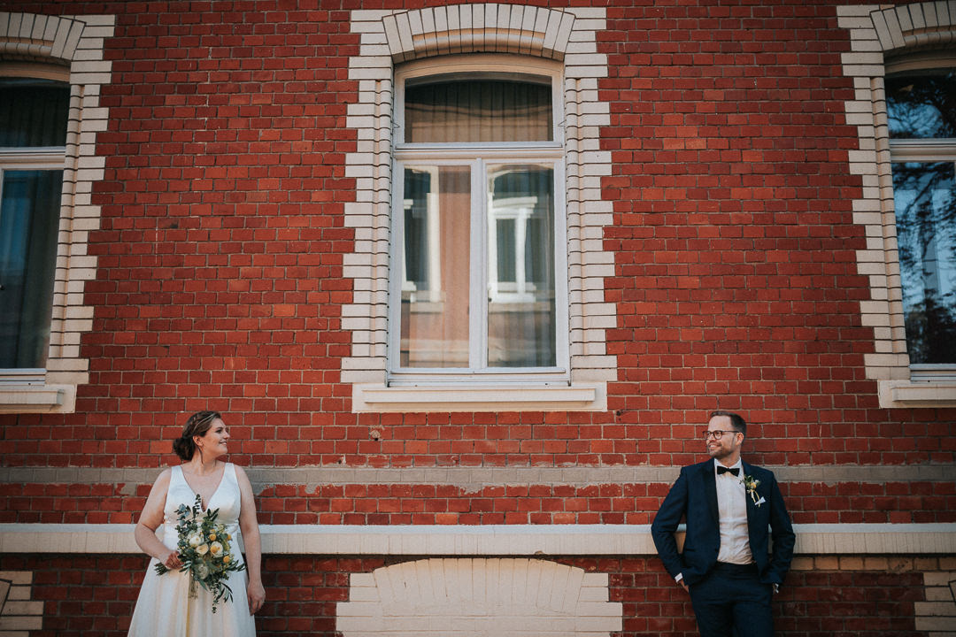 Brautpaar an die Backstein Fassade des Heyligenstaedt gelehnt