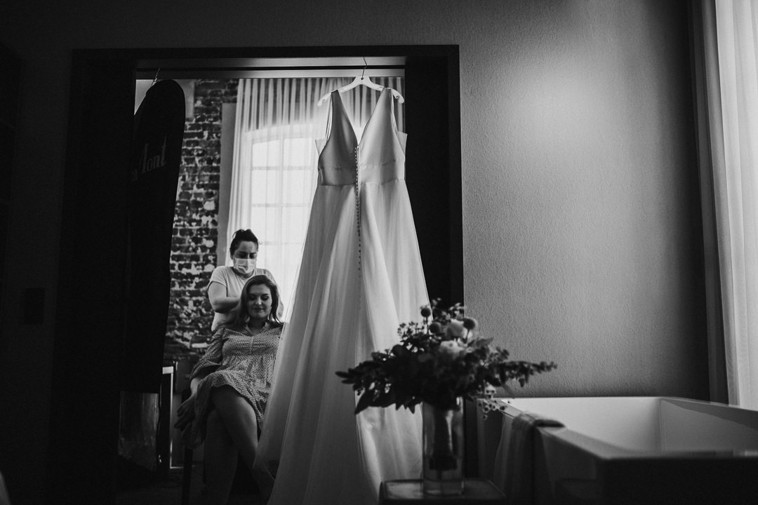Hochzeit-im-Heyligenstaedt Brautkleid hängt im Durchgang mit der Braut und Stylistin im Hintergrund
