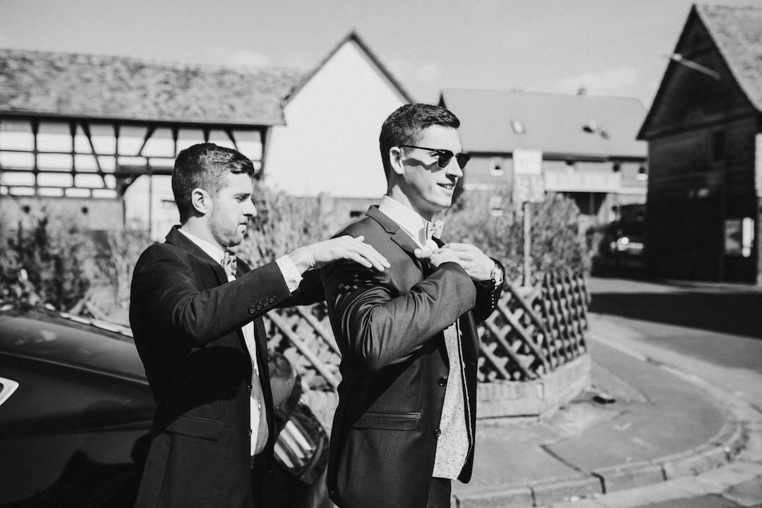 Hochzeit-Alte-Kirche-Niederweimar Trauzeuge hilft Bräutigam mit dem Sakko
