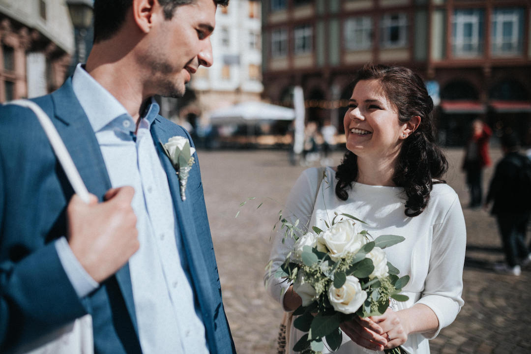 Braut lacht mit ihrem Bräutigam vor der Trauung im Römer Frankfurt