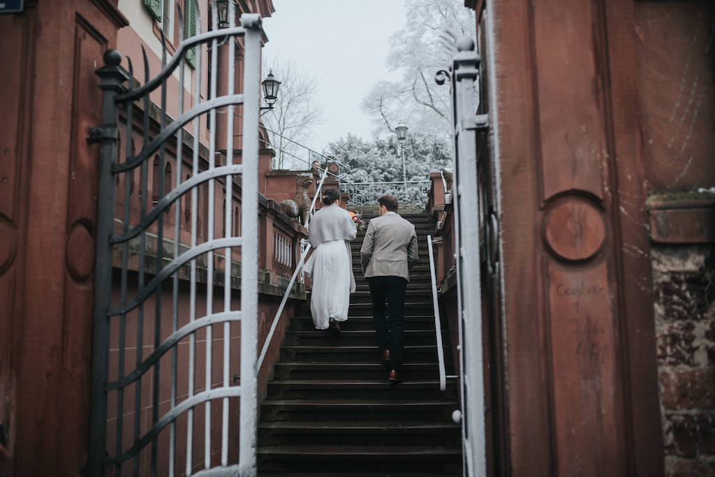 Brautpaar geht die Treppen hoch zum Bolongaropalast