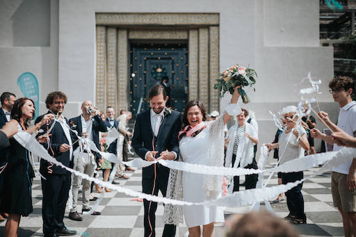 Hochzeitsfotograf-Frankfurt-Auszug.jpg Braut und Bräutigam laufen durch ein Spalier der Hochzeitsgäste.
