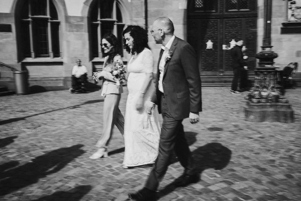 Brautpaar in Schwarz Weiß geht zum Mainufer in Frankfurt