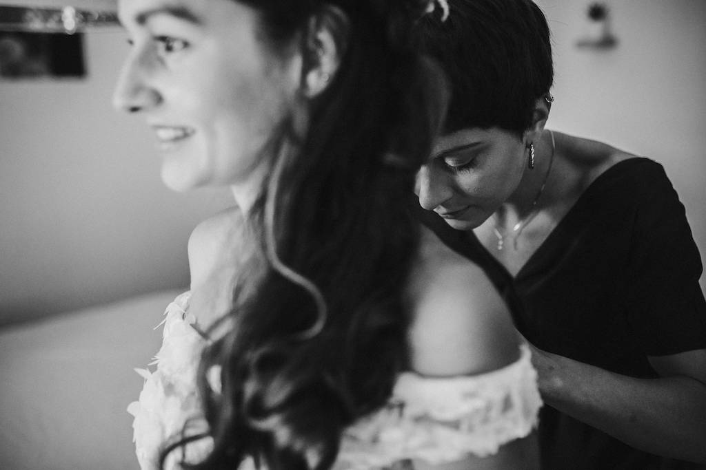 Getting-Ready-Hochzeit-Gießen.jpg Trauzeugin knöpft der Braut das Kleid zu