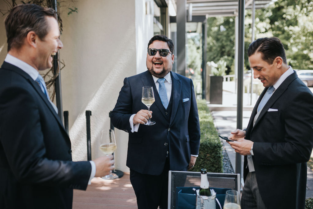 Hochzeit-auf-Burg-Schwarzenstein-Getting-Ready.jpg Bräutigam trinkt Champagner mit seinen Trauzeugen.