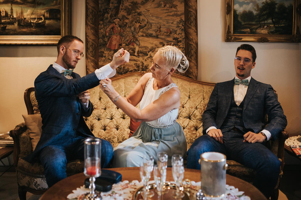 Hochzeit-auf-Gut-Nettehammer Mutter hilft ihrem Sohn beim Zurechtmachen.